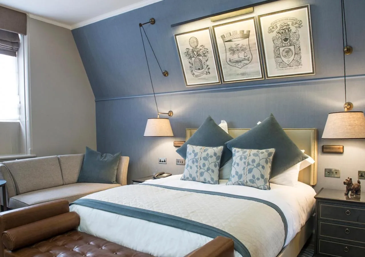 a bedroom with a bed and a couch at voco Grand Central Glasgow by IHG in Glasgow